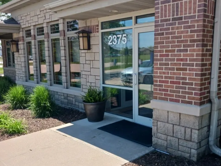 The glass entrance door marked 2375 at the Berkshire Parkway office in Clive, between brick and stone walls.