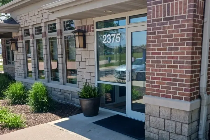 The office entrance at 2375 Berkshire Parkway, with the number on the glass door and a planter beside it.
